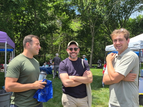 Jack Richardson talking with two residents at an outdoor community cookout