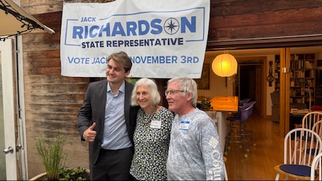 Jack Richardson with supporters at a house party under a campaign banner